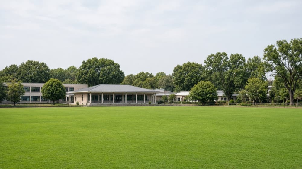 Green playing fields and pavilion on a school sports campus